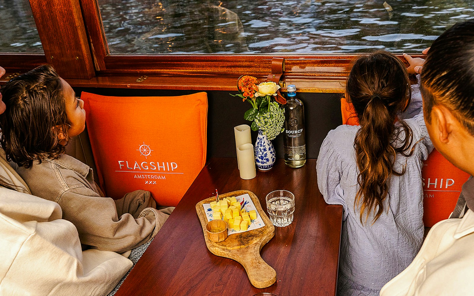 Guests enjoying cheese and wine on a luxury canal cruise in Amsterdam.