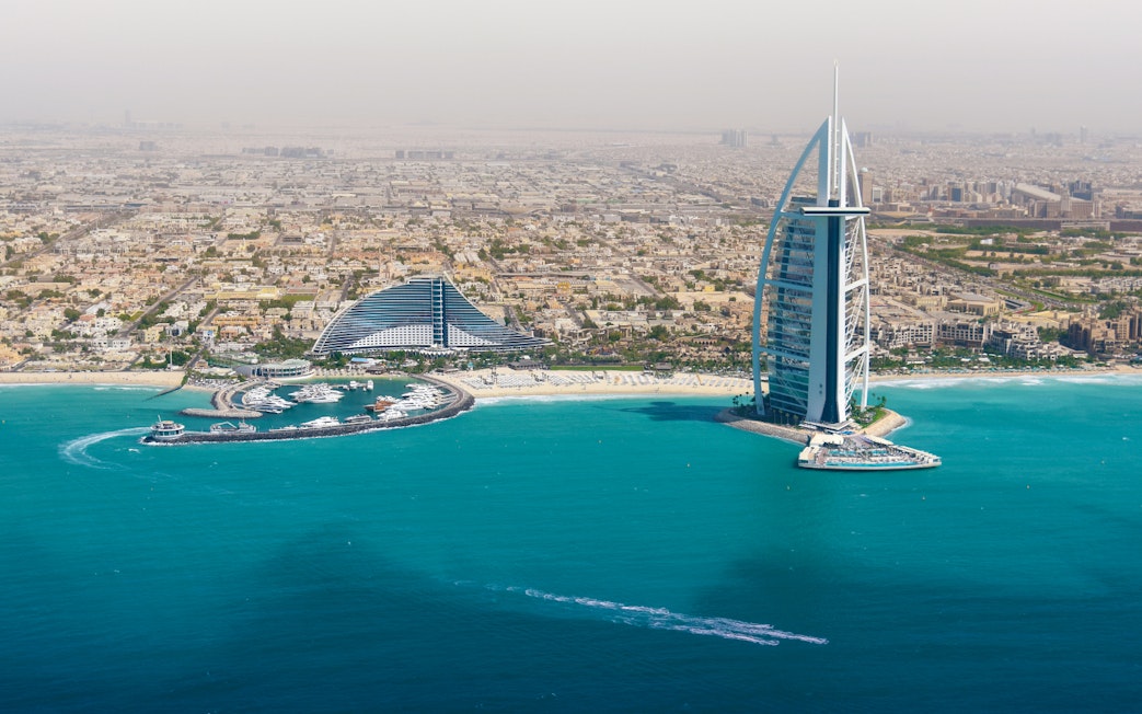 Dubai skyline with Burj Al Arab and coastline from helicopter view.