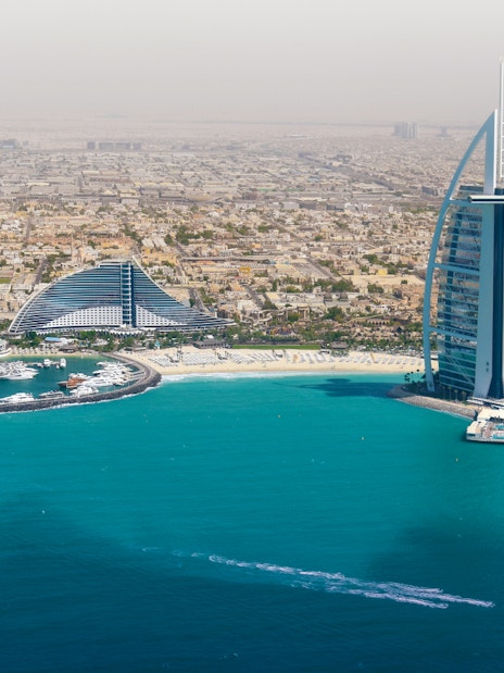 Dubai skyline with Burj Al Arab and coastline from helicopter view.