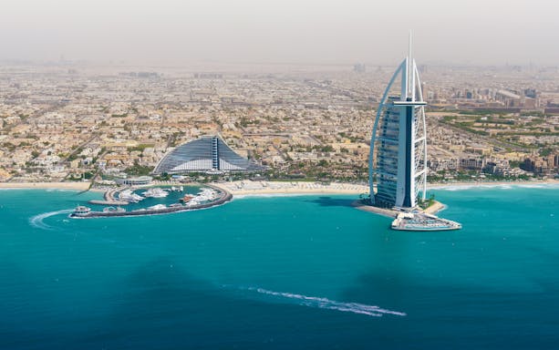 Dubai skyline with Burj Al Arab and coastline from helicopter view.