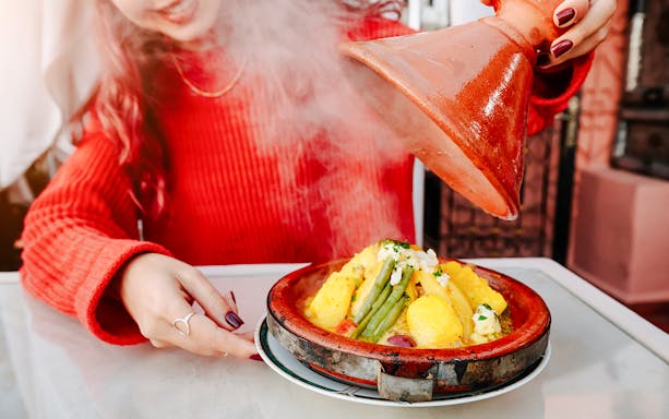 Tagine dish being served at Jema el Fna street food market in Marrakesh.