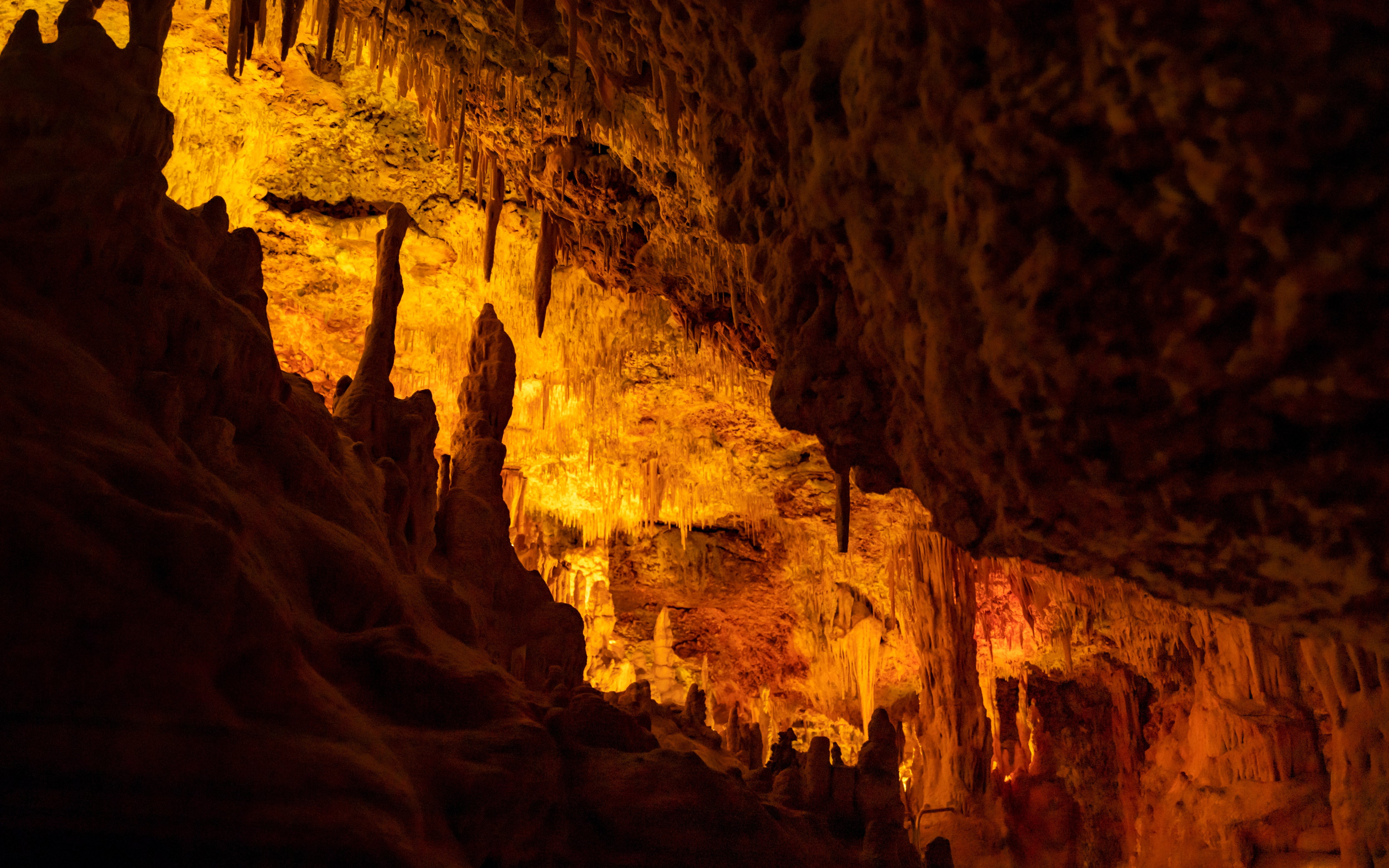 Stalactites and stalagmites in the illuminated interiors of Drach Caves, Mallorca.