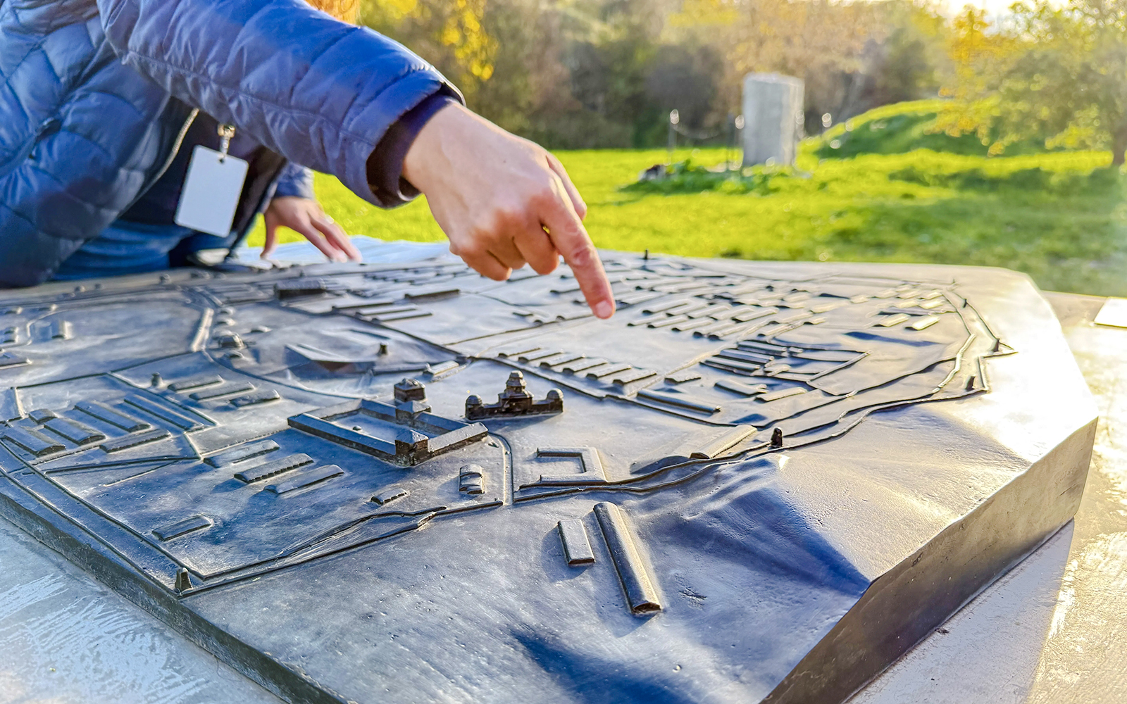 Tour guide pointing at a model of Płaszów Concentration Camp during guided tour.