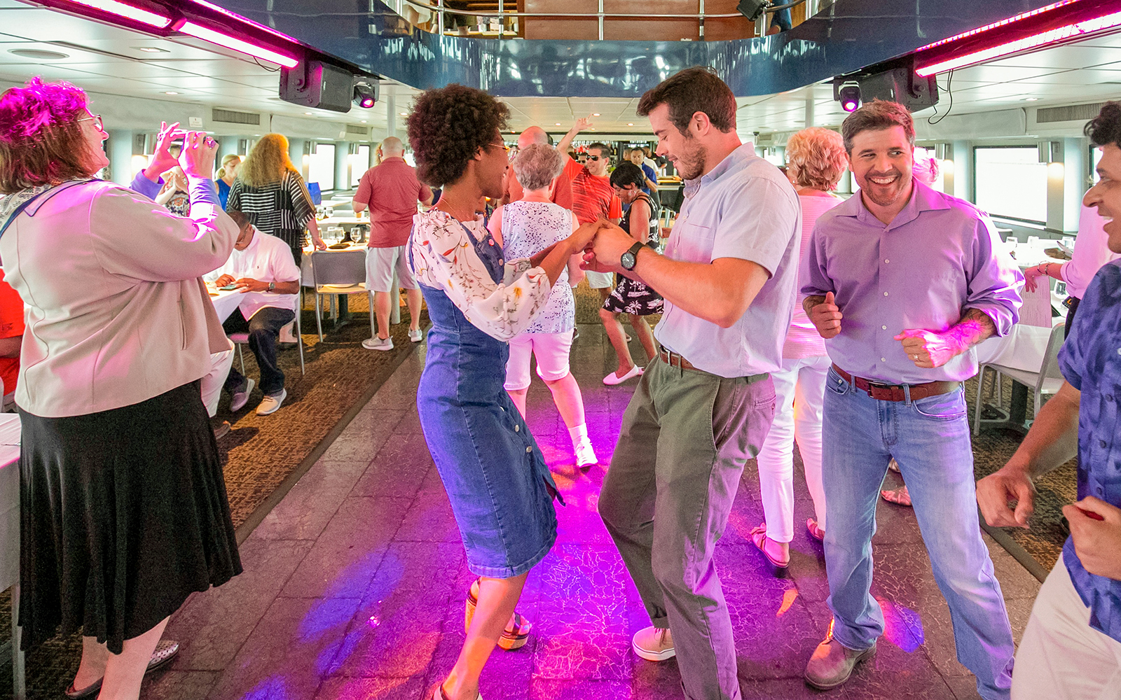 Guests dancing in the dining area aboard a New York City lunch cruise.