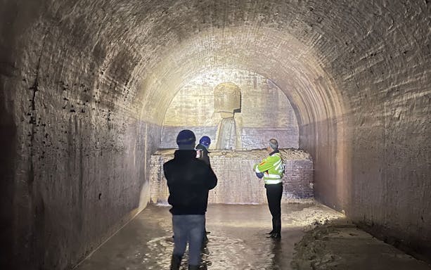 Visitors exploring a historic underground tunnel in Ancona.
