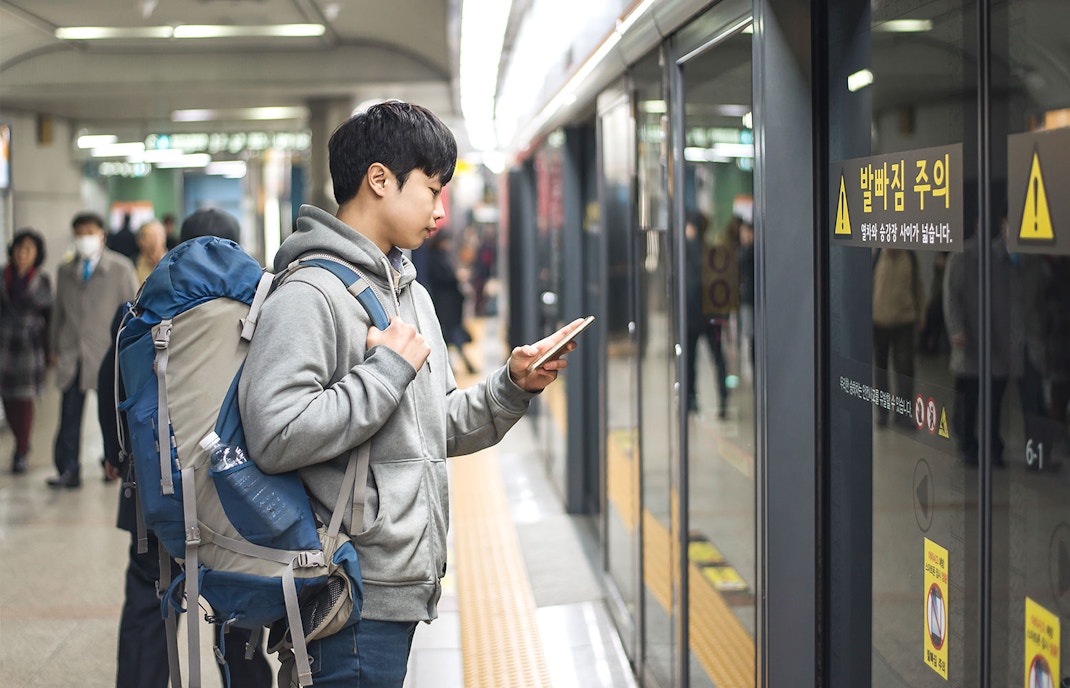 Man waiting on subway platform in Seoul, South Korea.