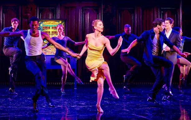 Dancers performing a lively routine on stage, showcasing "Gotta Dance!" tour.