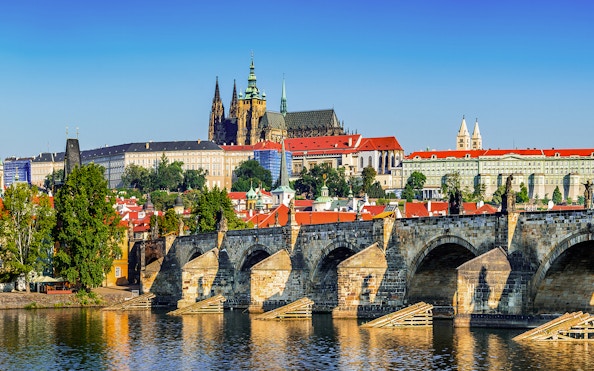 Prague Castle and Charles Bridge viewed from a cycle boat on the Vltava River.