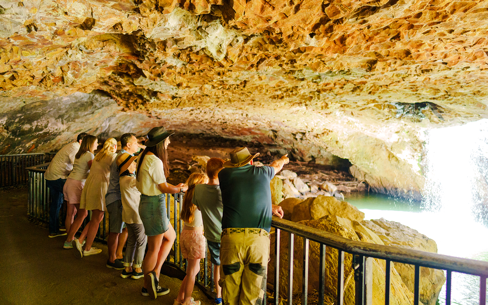 Visitors observing waterfall inside Natural Bridge cave, Springbrook National Park.