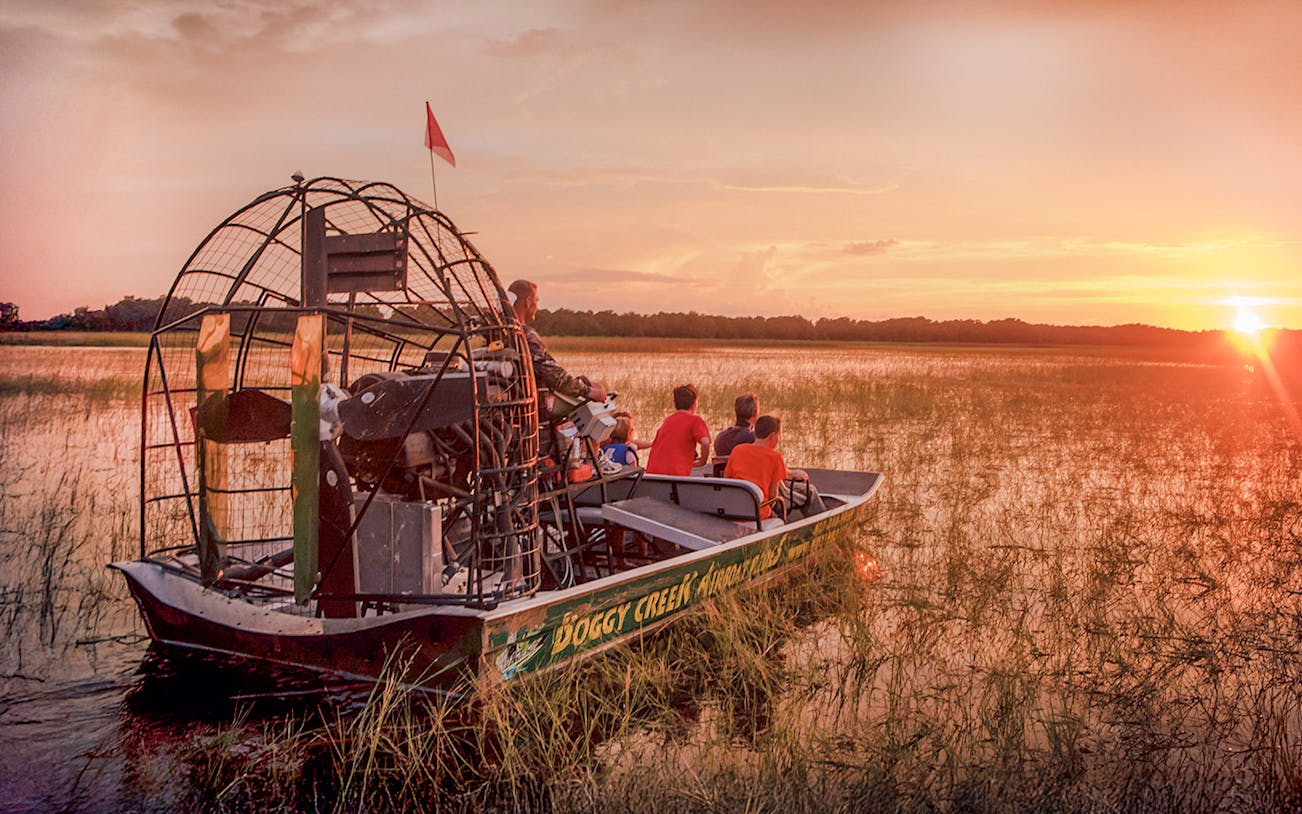 Guests on an airboat tour at sunset in Boggy Creek, Florida.