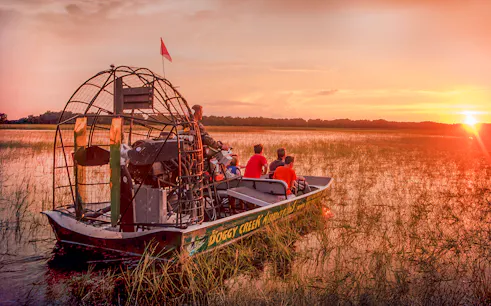 Guests on an airboat tour at sunset in Boggy Creek, Florida.