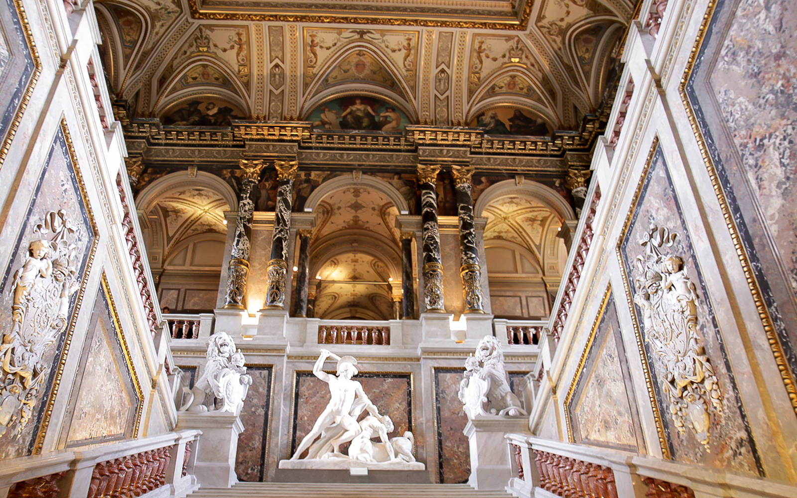 Kunsthistorisches Museum Vienna interior with ornate ceiling and classical sculptures.