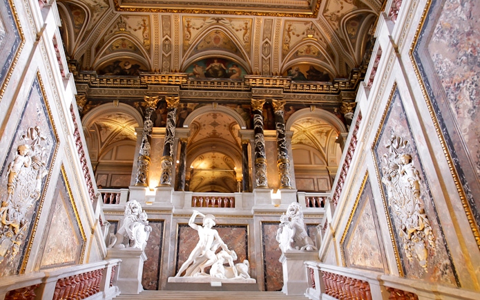 Kunsthistorisches Museum Vienna interior with ornate ceiling and classical sculptures.