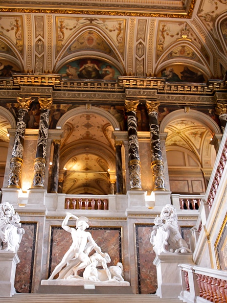 Kunsthistorisches Museum Vienna interior with ornate ceiling and classical sculptures.