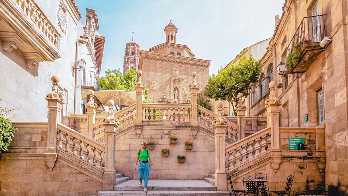 Tourists exploring Poble Espanyol in Barcelona with Skip-the-Line Tickets, admiring the unique architecture and vibrant streets