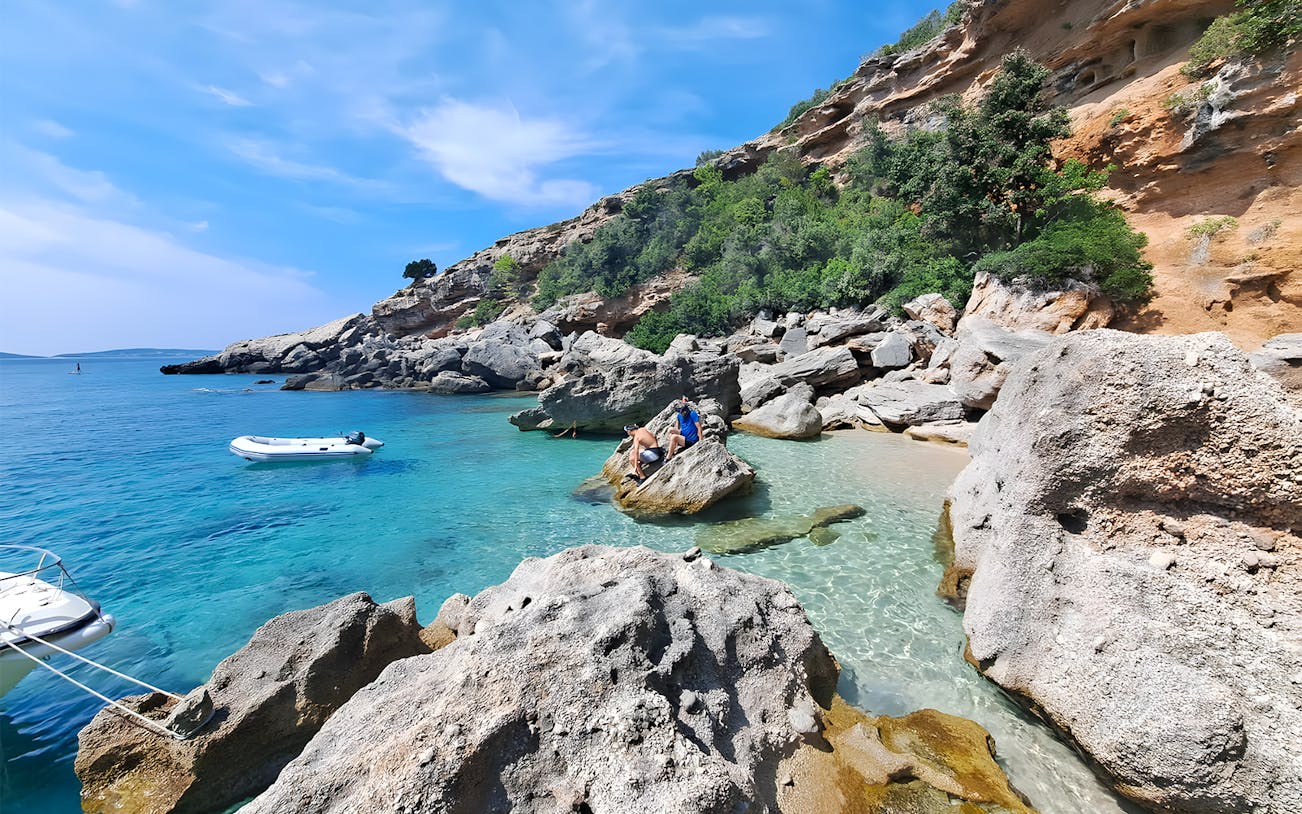 Snorkeling and swimming at a secluded beach in Korčula, Dubrovnik with rocky cliffs and clear blue water.