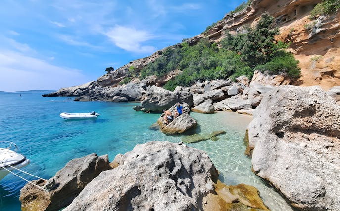 Snorkeling and swimming at a secluded beach in Korčula, Dubrovnik with rocky cliffs and clear blue water.