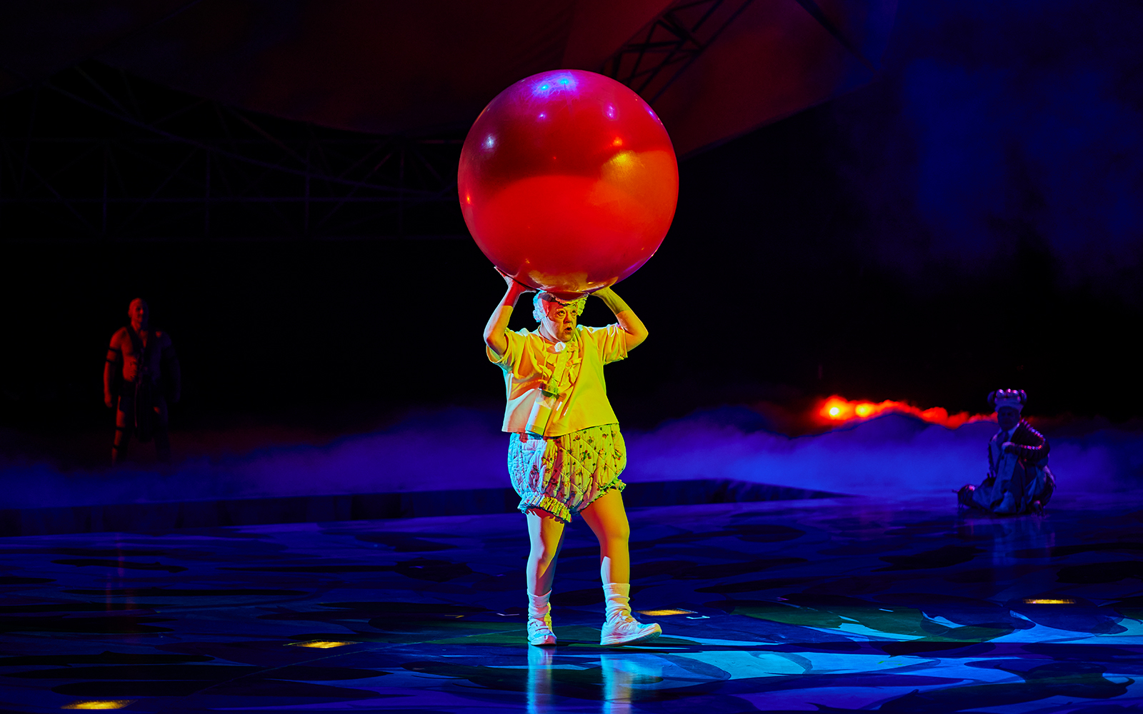 Performer balancing a large red ball during Mystère show.