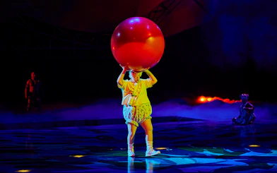 Performer balancing a large red ball during Mystère show.