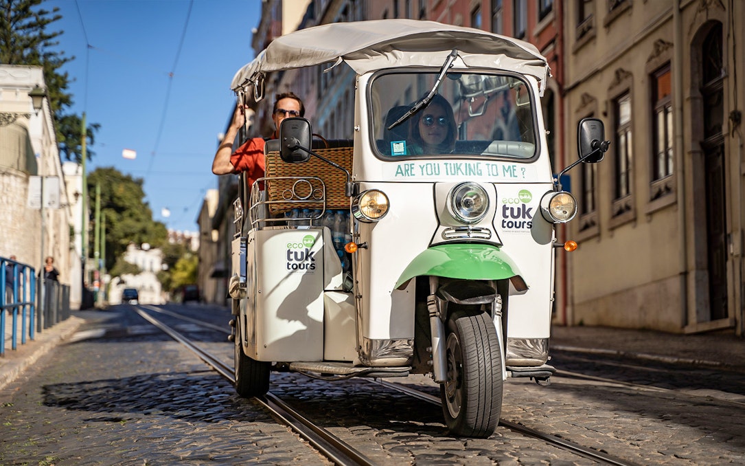 Private electric tuk tuk on cobblestone street during half day sightseeing tour.
