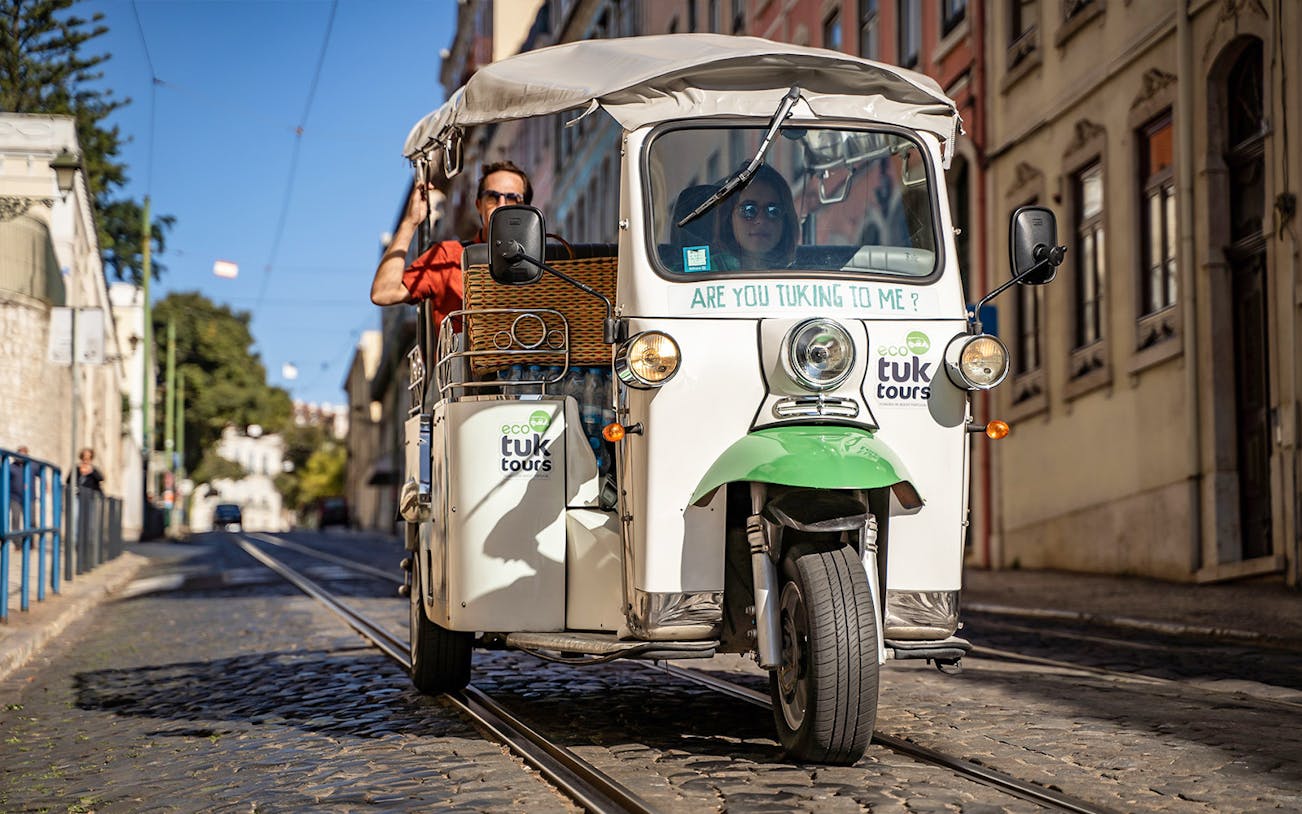 Private electric tuk tuk on cobblestone street during half day sightseeing tour.