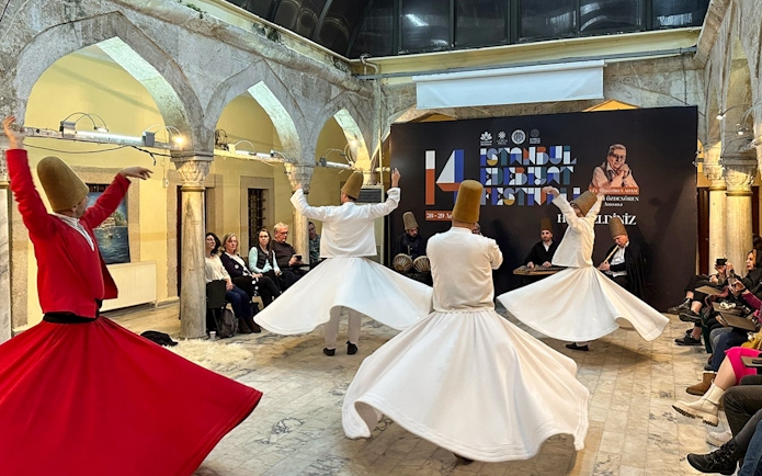 Whirling Dervishes performing at Mevlevi Sema ceremony in Istanbul, with audience watching.
