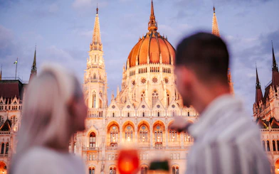 Couple viewing Budapest Parliament from Danube River nighttime cruise.