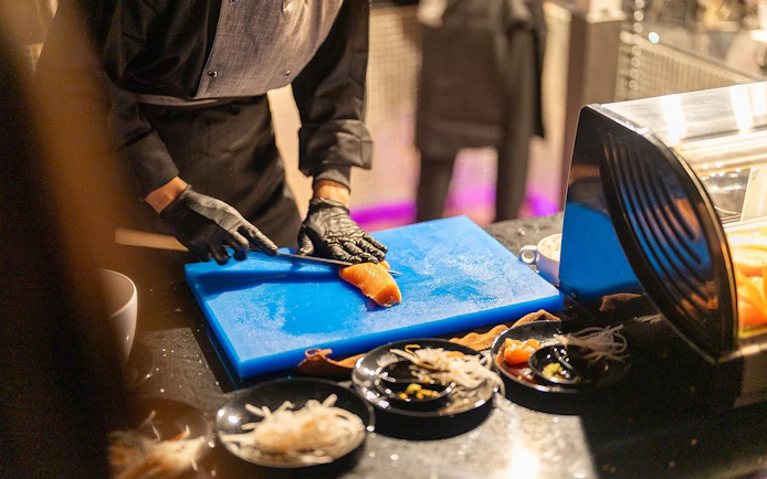Chef preparing salmon sashimi on Super Galaxy Luxury Chao Phraya River Dinner Cruise.