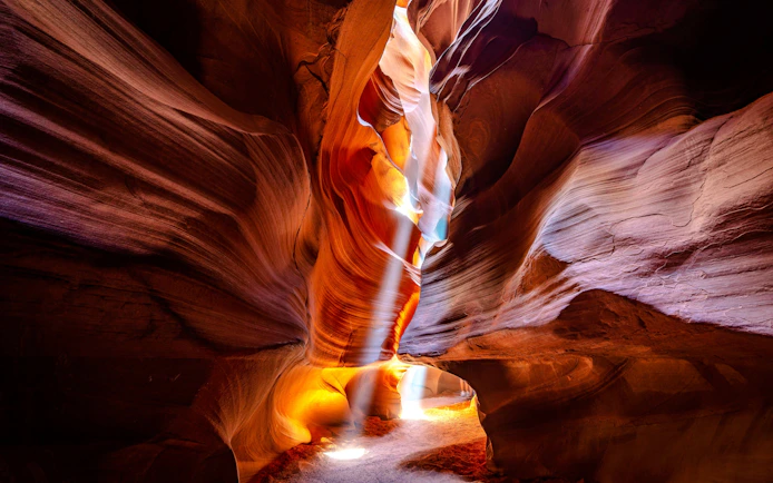 Antelope Canyon's sandstone walls with light beams, part of a small group tour.