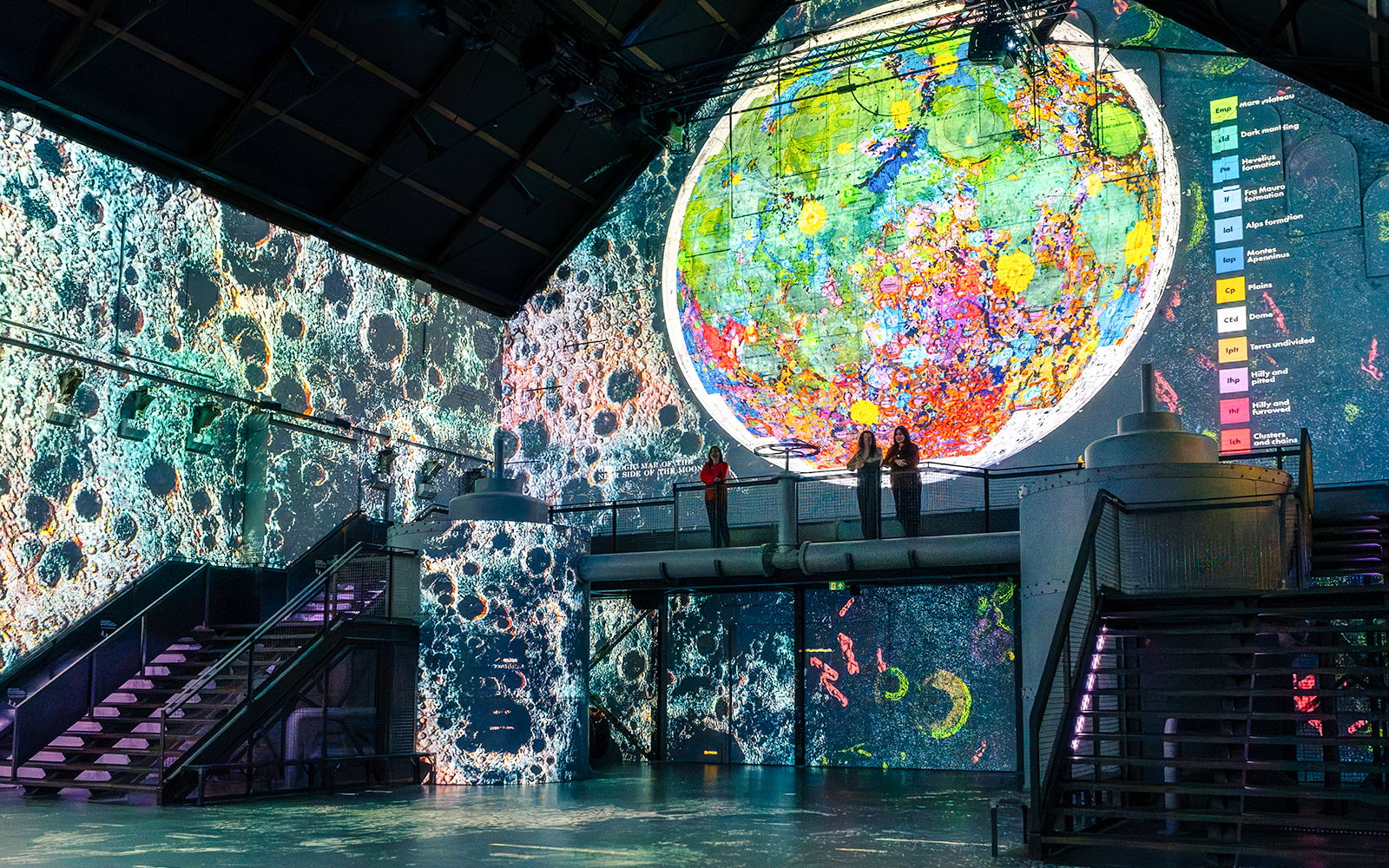 Guests viewing lunar art projections at Moonwalkers Exhibition, Fabrique des Lumières, Amsterdam.