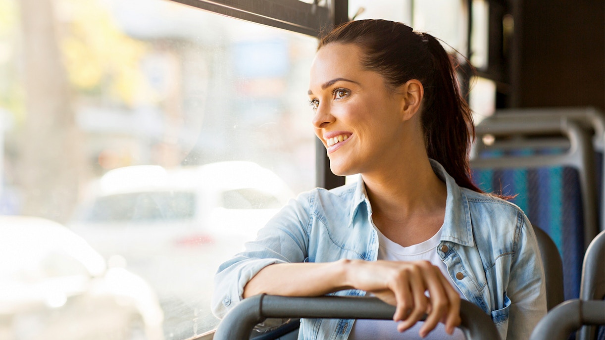Young woman on a bus ride through city streets, exploring local attractions.