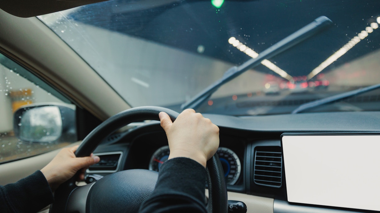 Driving through a tunnel with windshield wipers on, view from inside the car.