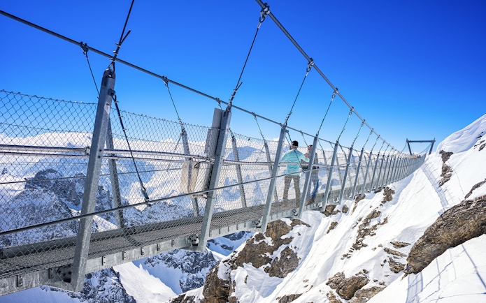 Titlis Cliff Walk suspension bridge over snowy peaks in Engelberg, Switzerland.