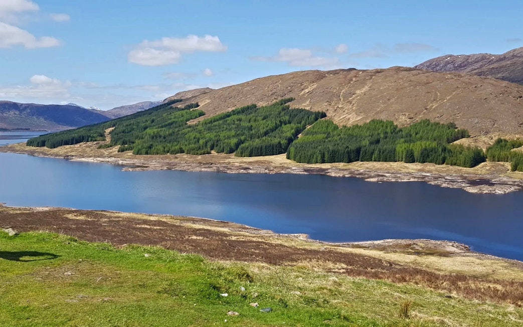 Loch Loyne with surrounding hills and forests in the Northwest Highlands of Scotland.