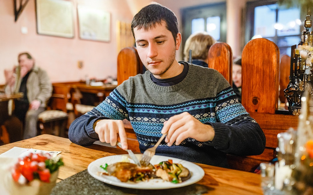Man enjoying traditional Czech dinner during Prague beer tour.