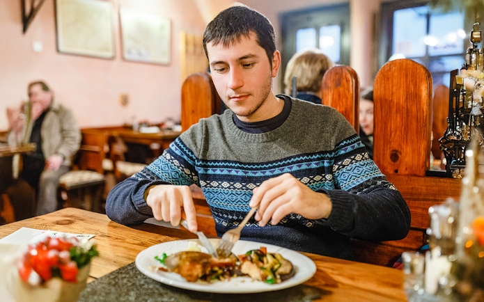 Man enjoying traditional Czech dinner during Prague beer tour.