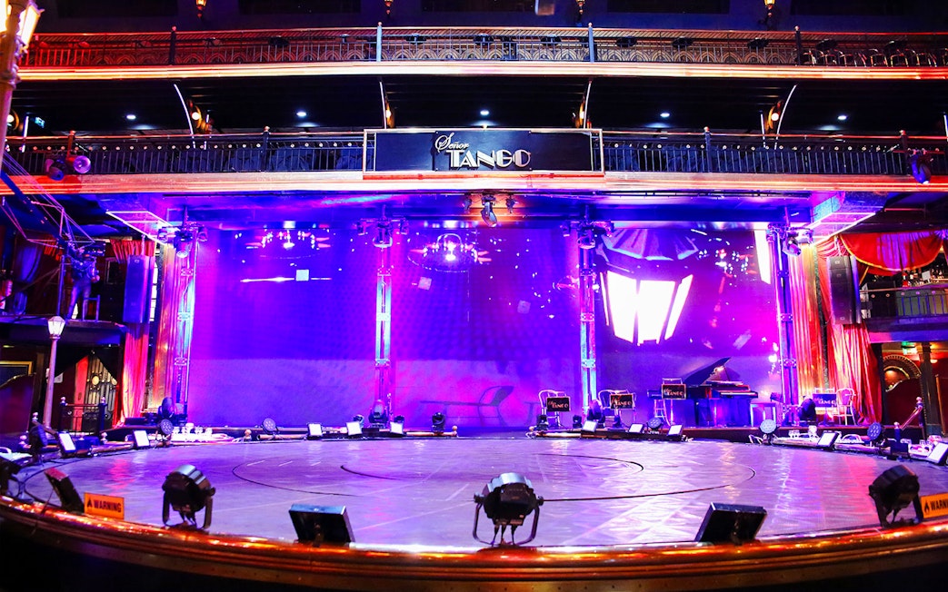 Stage area at Señor Tango Show with vibrant lighting and musical instruments.