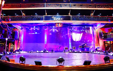 Stage area at Señor Tango Show with vibrant lighting and musical instruments.