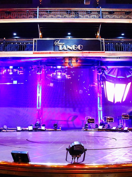 Stage area at Señor Tango Show with vibrant lighting and musical instruments.