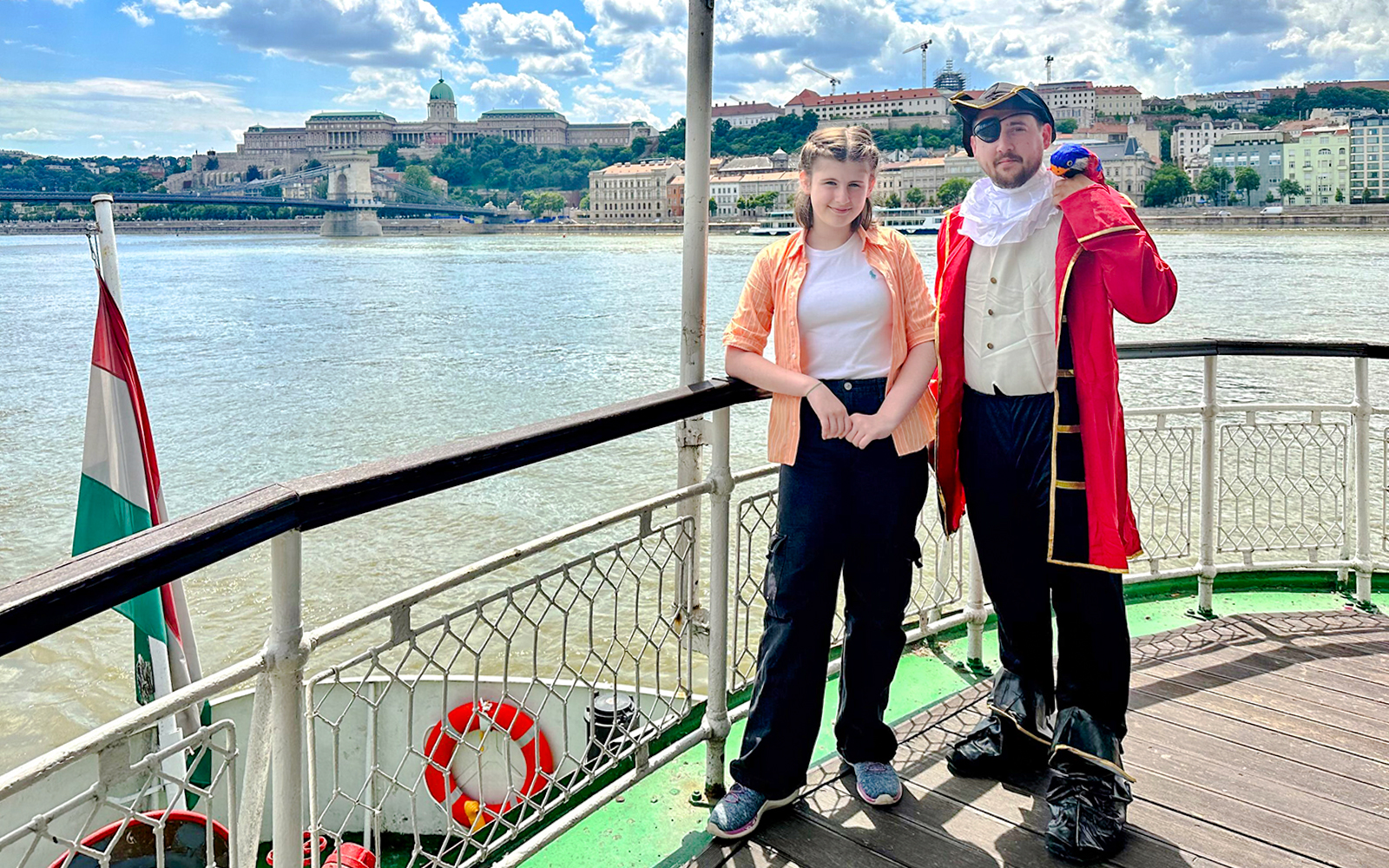 Passengers enjoying the Sunshine Booze Cruise with Buda Castle view, Budapest.