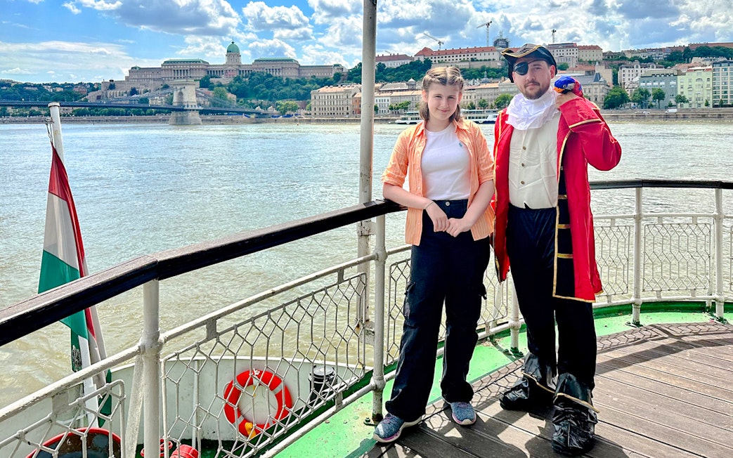 Passengers enjoying the Sunshine Booze Cruise with Buda Castle view, Budapest.