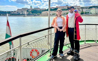 Passengers enjoying the Sunshine Booze Cruise with Buda Castle view, Budapest.