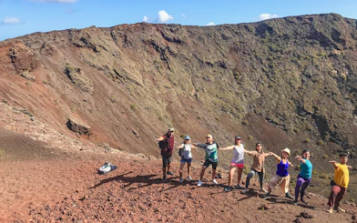 Group trekking along volcanic terrain at Timanfaya National Park, Lanzarote.