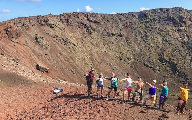 Group trekking along volcanic terrain at Timanfaya National Park, Lanzarote.