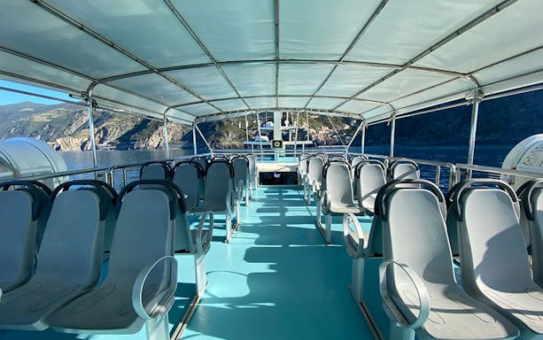Open-air boat seating with coastal view on Riomaggiore, Monterosso, and Vernazza tour from La Spezia.