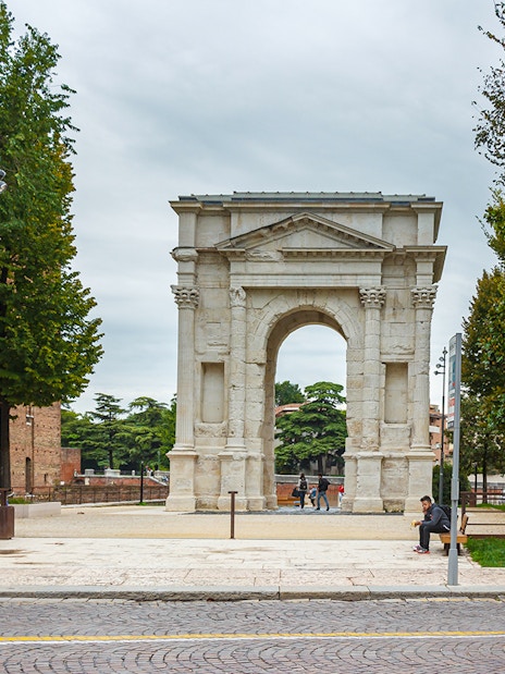 Verona's Porta Borsari arch with tourists nearby on a walking tour.