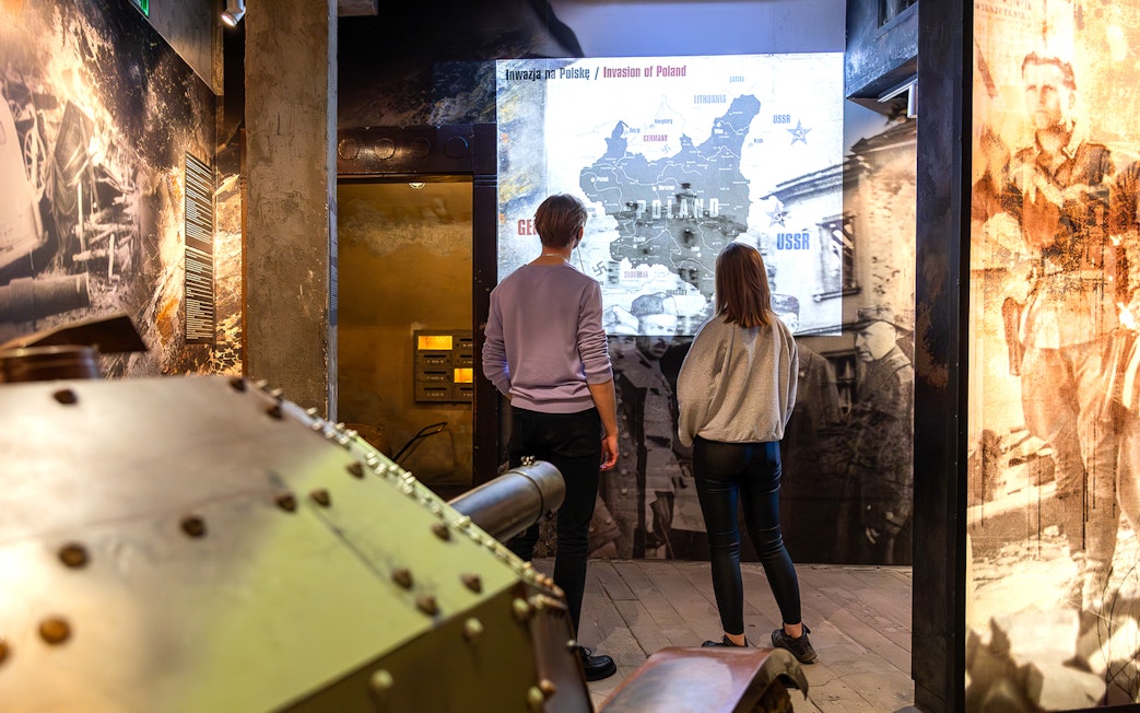 Visitors viewing Poland invasion map at Oskar Schindler's Factory exhibit.