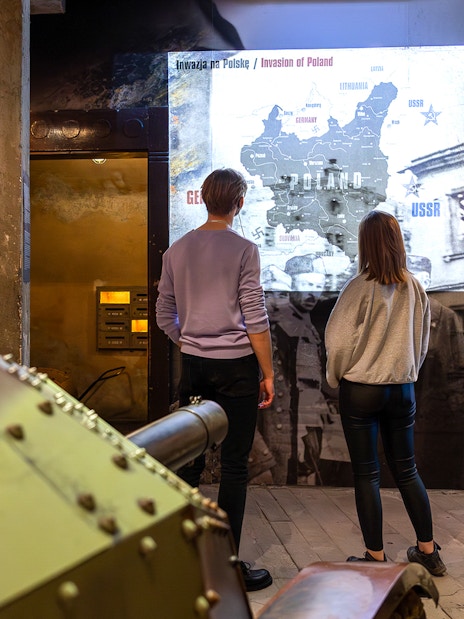 Visitors viewing Poland invasion map at Oskar Schindler's Factory exhibit.