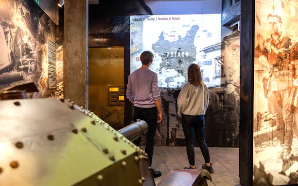 Visitors viewing Poland invasion map at Oskar Schindler's Factory exhibit.