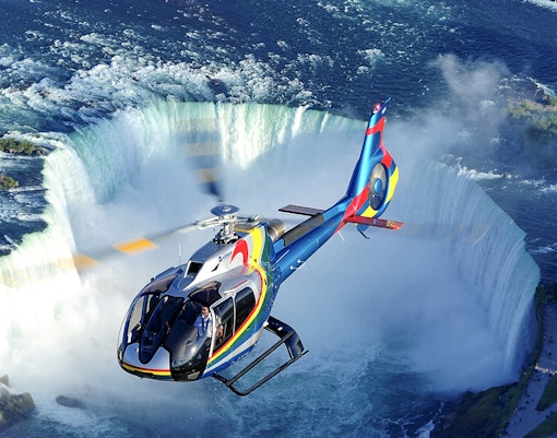 Helicopter flying over the breathtaking Niagara Falls, offering a unique aerial tour experience